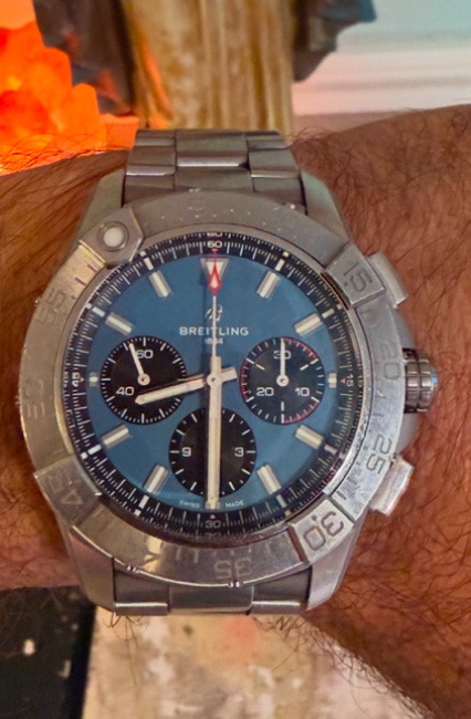 A steel Breitling Avenger chronograph with a blue dial, worn on David's wrist.