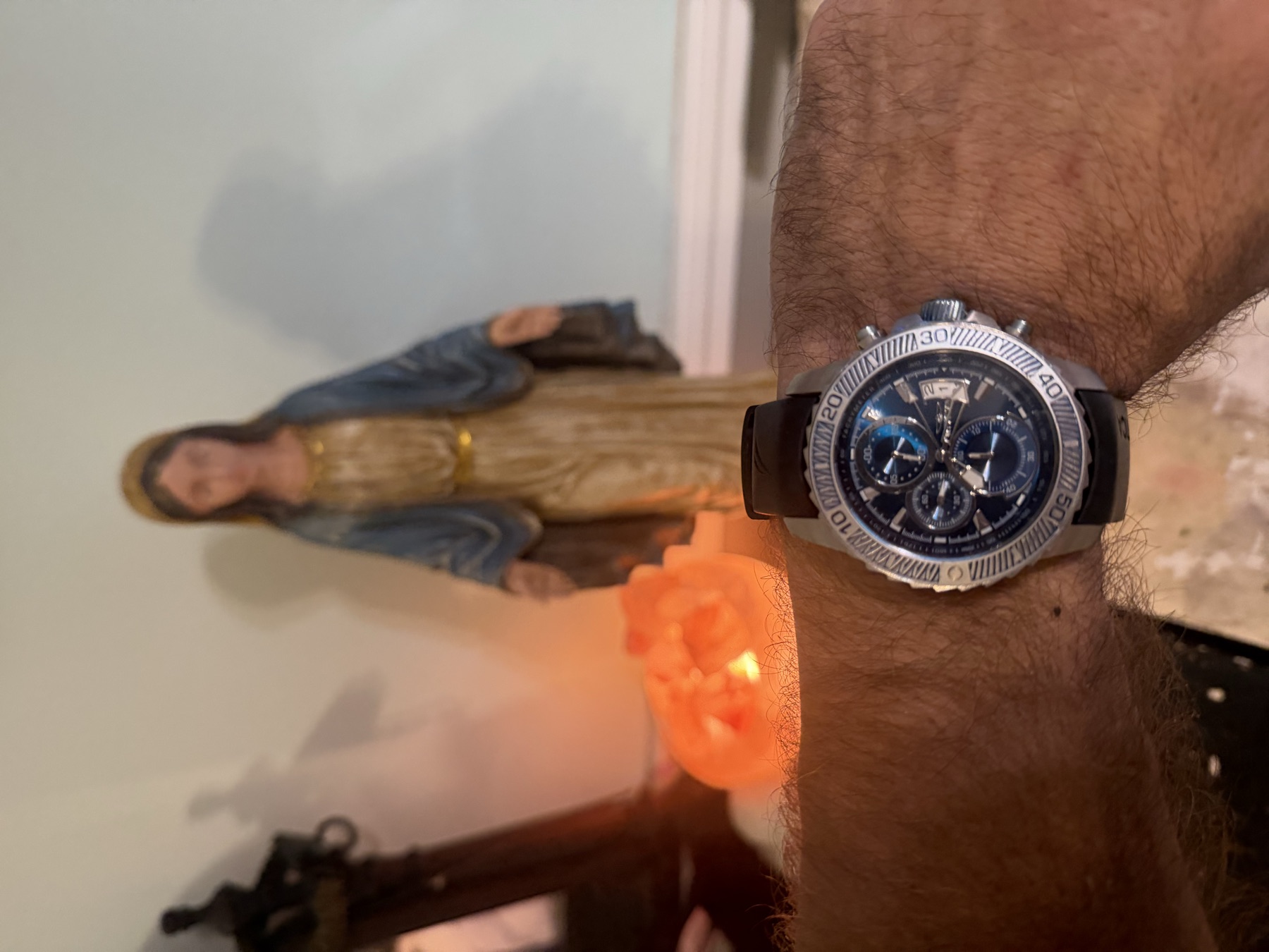 A steel chronograph on a black rubber strap, worn on David's wrist.